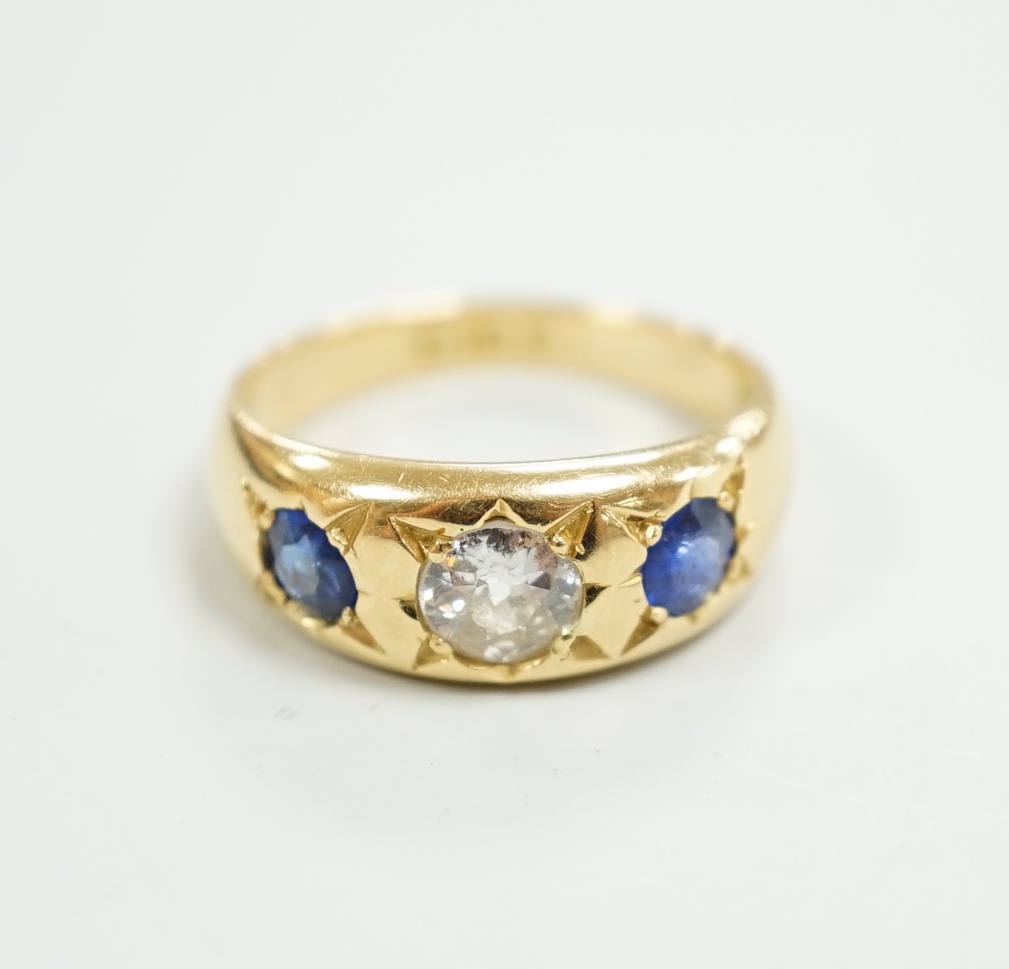 An early 20th century 18ct gold and gypsy set single stone diamond and two stone sapphire set ring, size O, gross weight 6.4 grams.